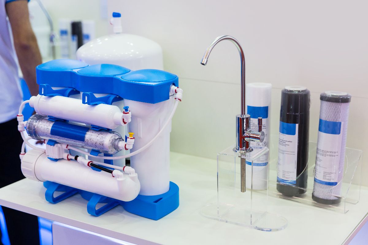 Reverse osmosis filtration unit with storage tank, faucet, and replacement cartridges displayed on a countertop